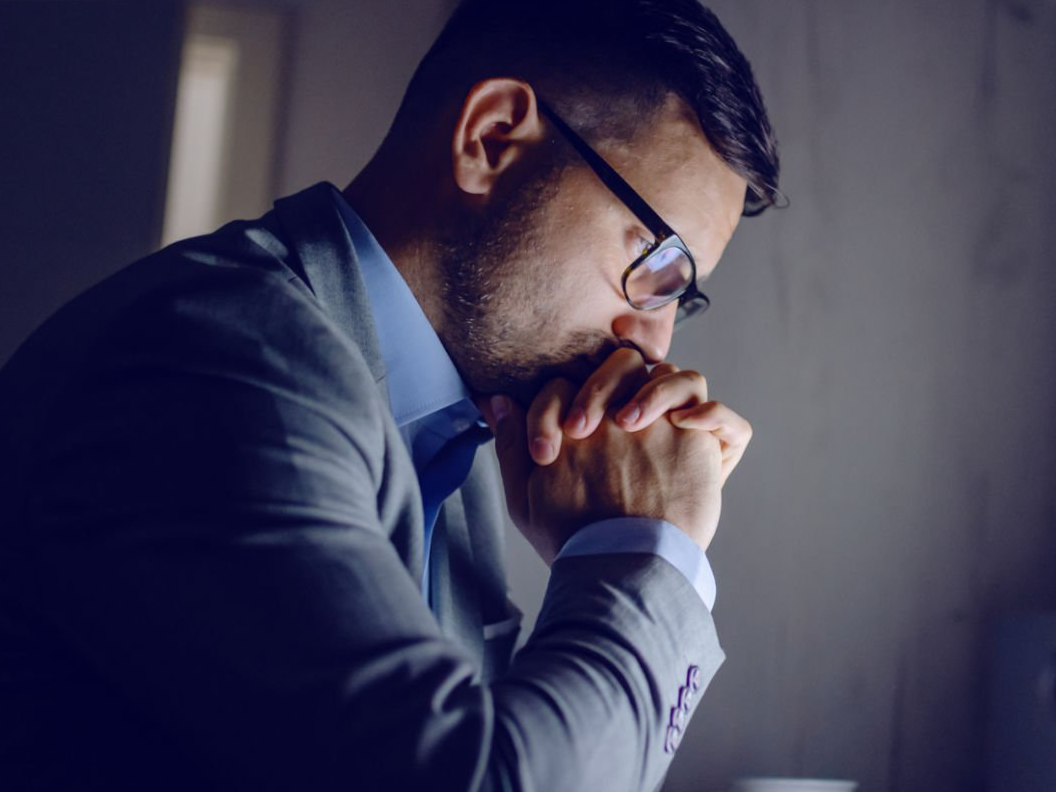 A side shot of a lawyer in a business suit reading a screen which is off camera.