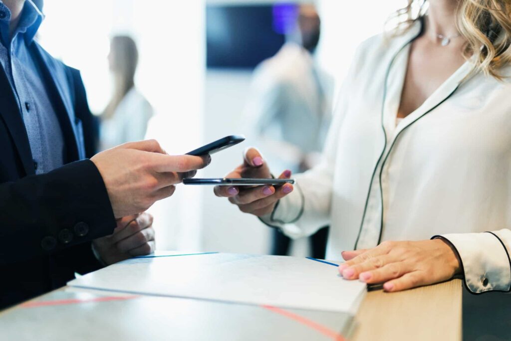 Close up of two people, one person is scanning the other person's phone.