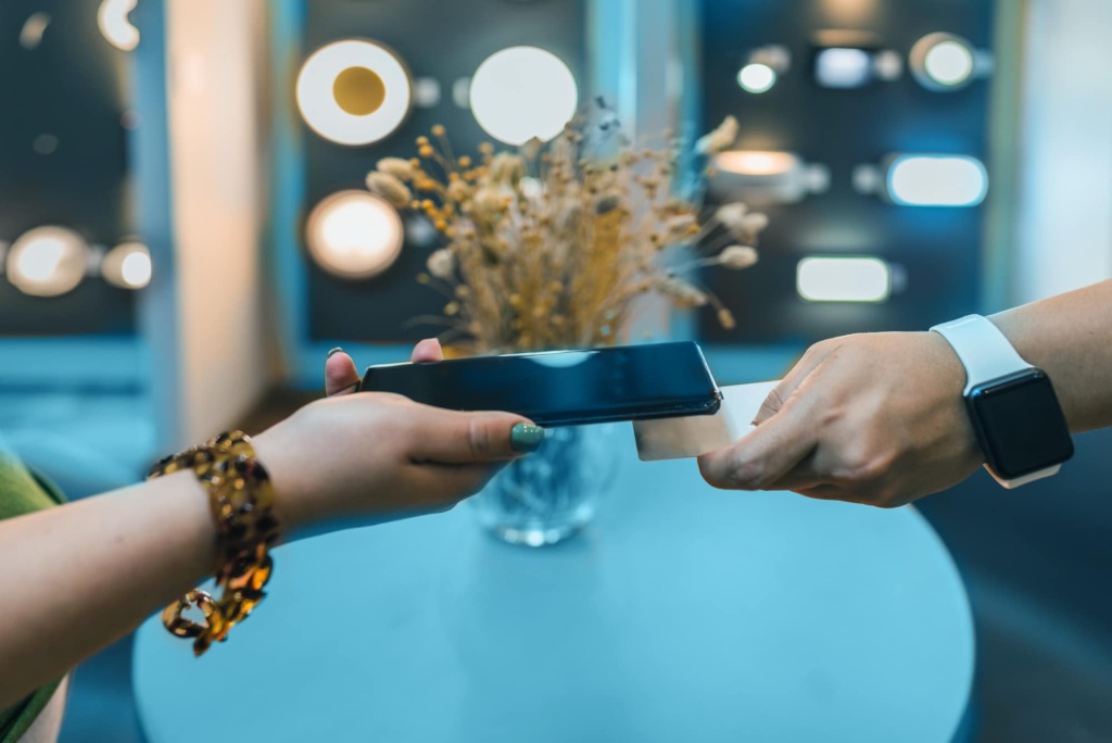 Close up of a person using their phone to scan the other person's business card.